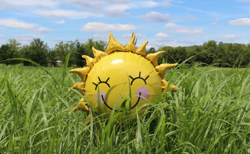 yellow inflatable sun at grass field